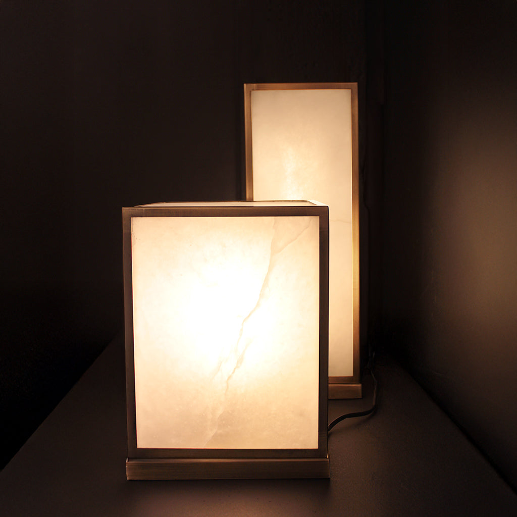Two rectangular table lamps with marble finishes on a dark background