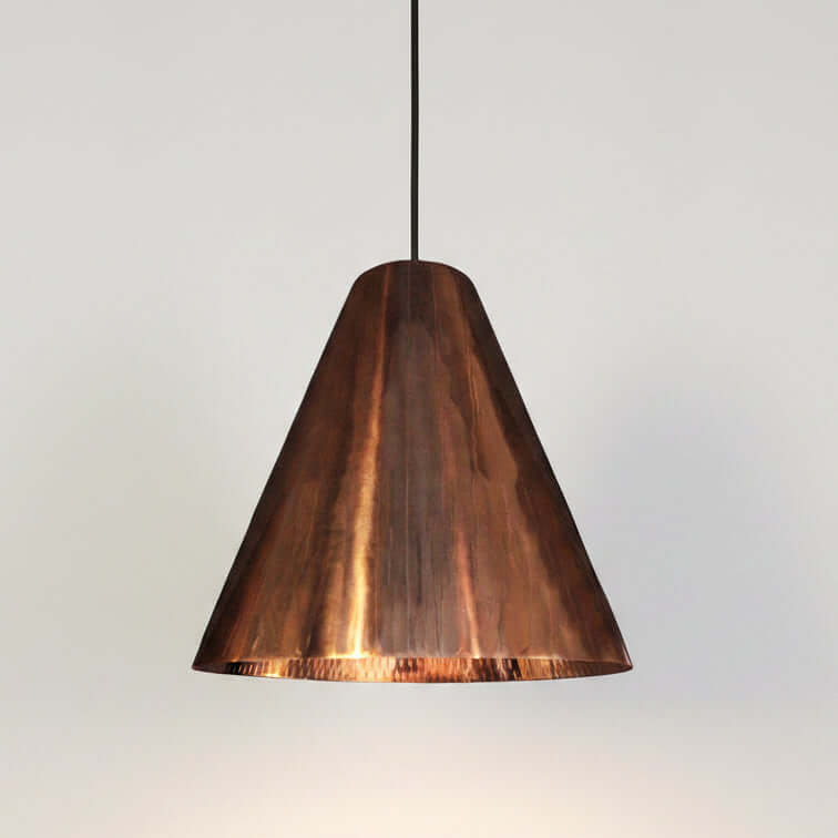 Dining room with wooden table, wicker chairs, and a copper pendant light.