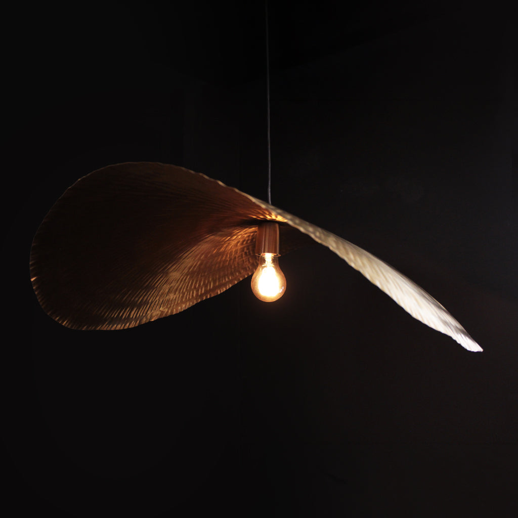 Decorative pendant light with feather-like design on a black background
