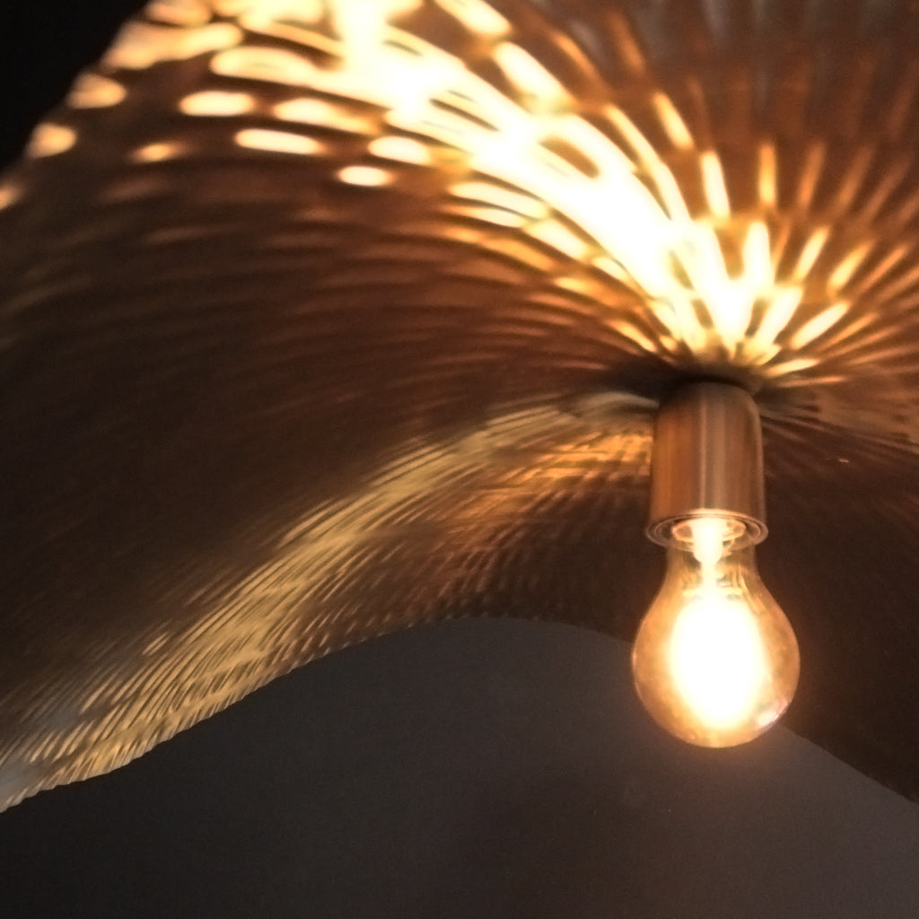 Light bulb hanging from a decorative ceiling fixture