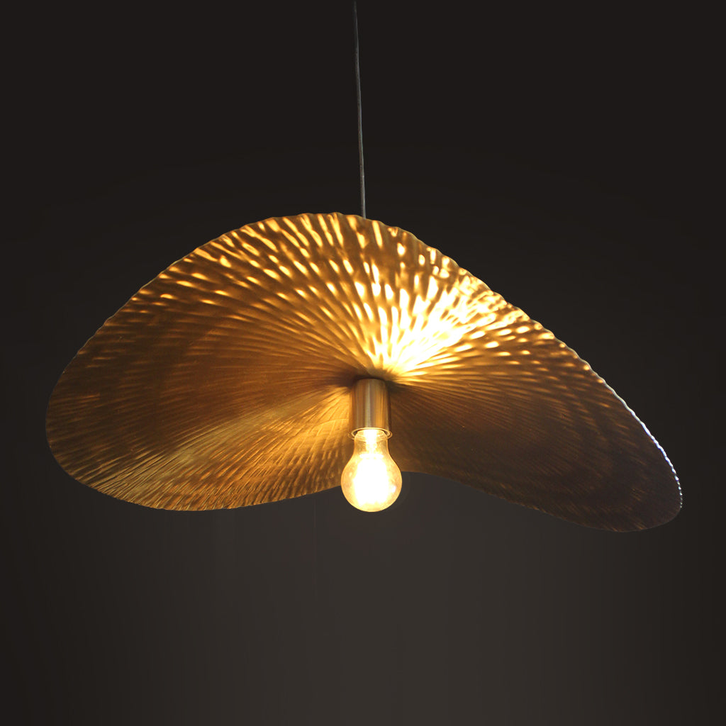 Gold leaf-like pendant light against a dark background