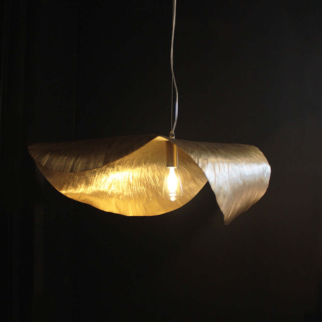 Gold pendant light fixture on a black background