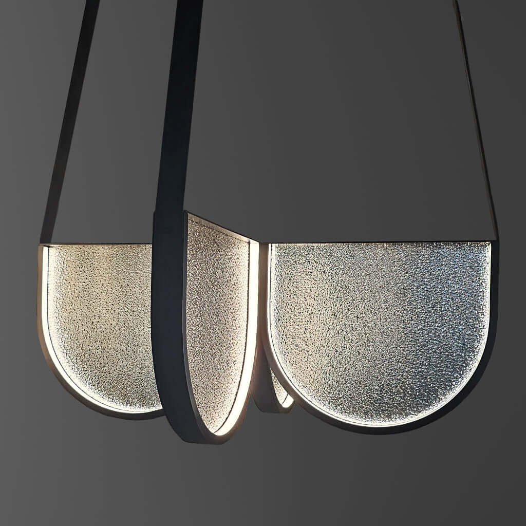 Modern pendant light with black and glass design on a dark background