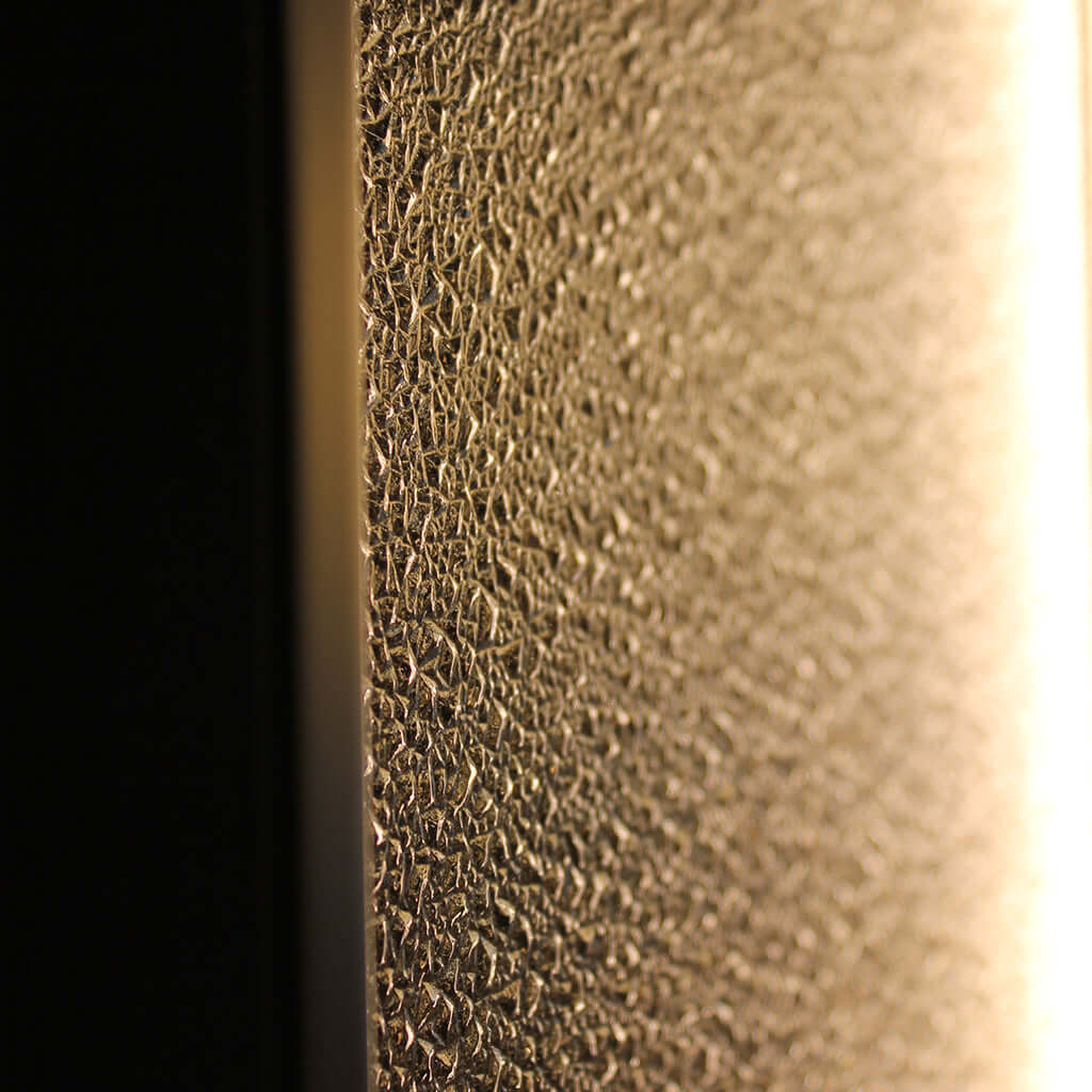 Close-up of a textured glass surface lit with warm light