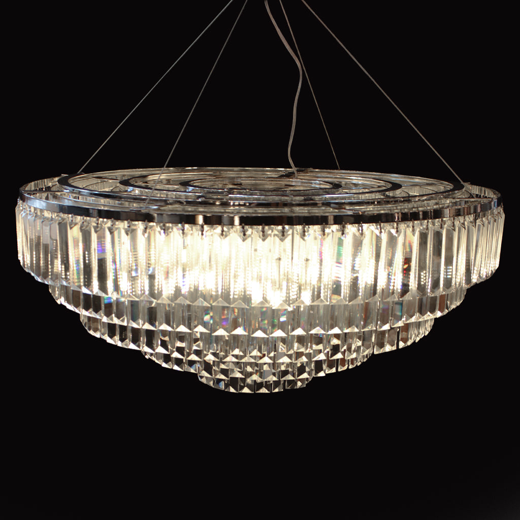 Tiered chandelier with hanging clear prism crystals and chrome frame on a black background
