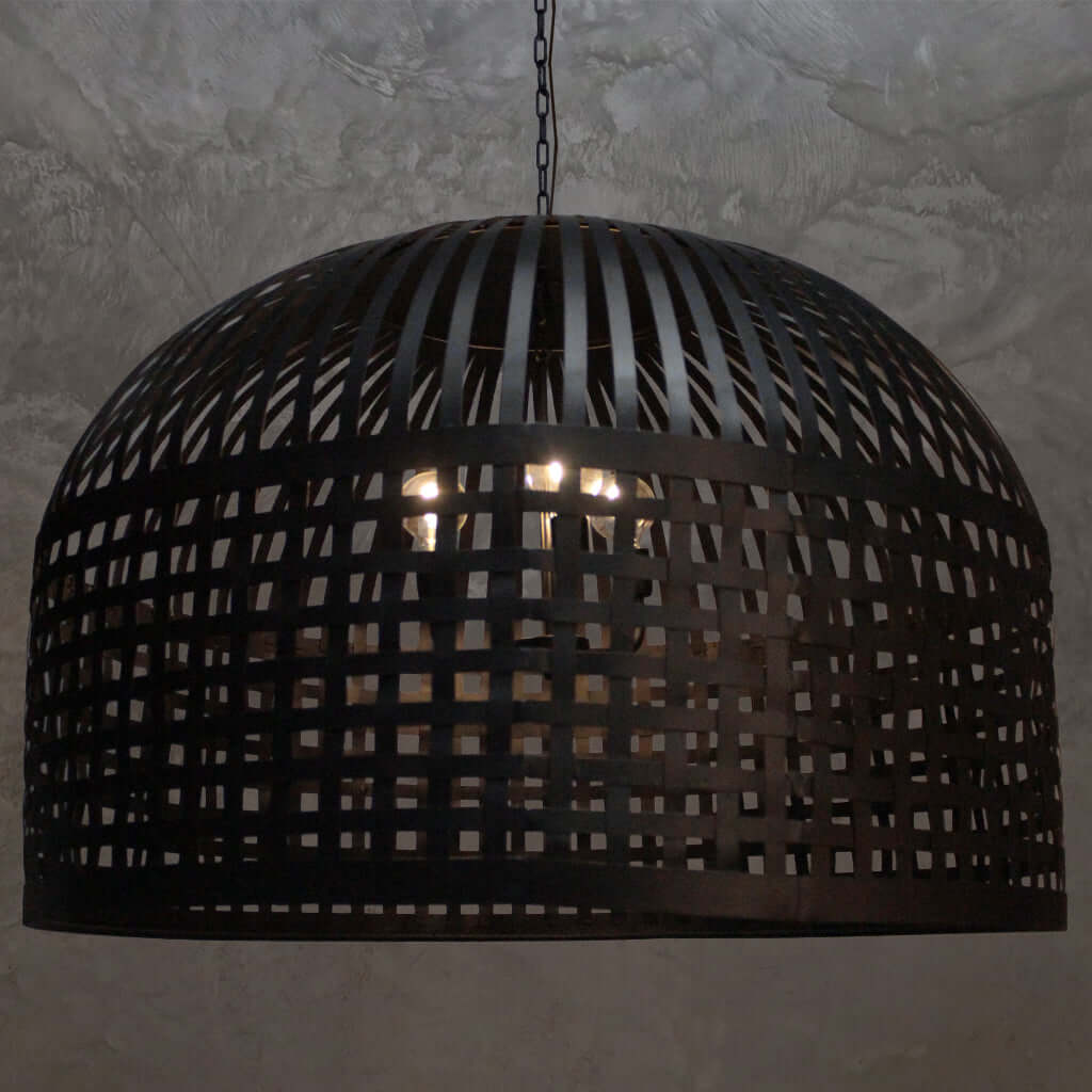 Dining room with wooden table and chairs under a large pendant light.