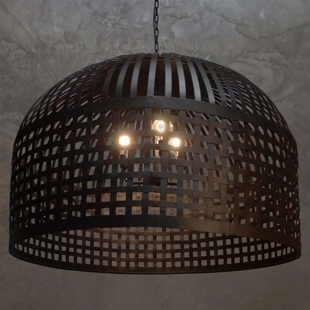 Black woven pendant light fixture on a textured wall background