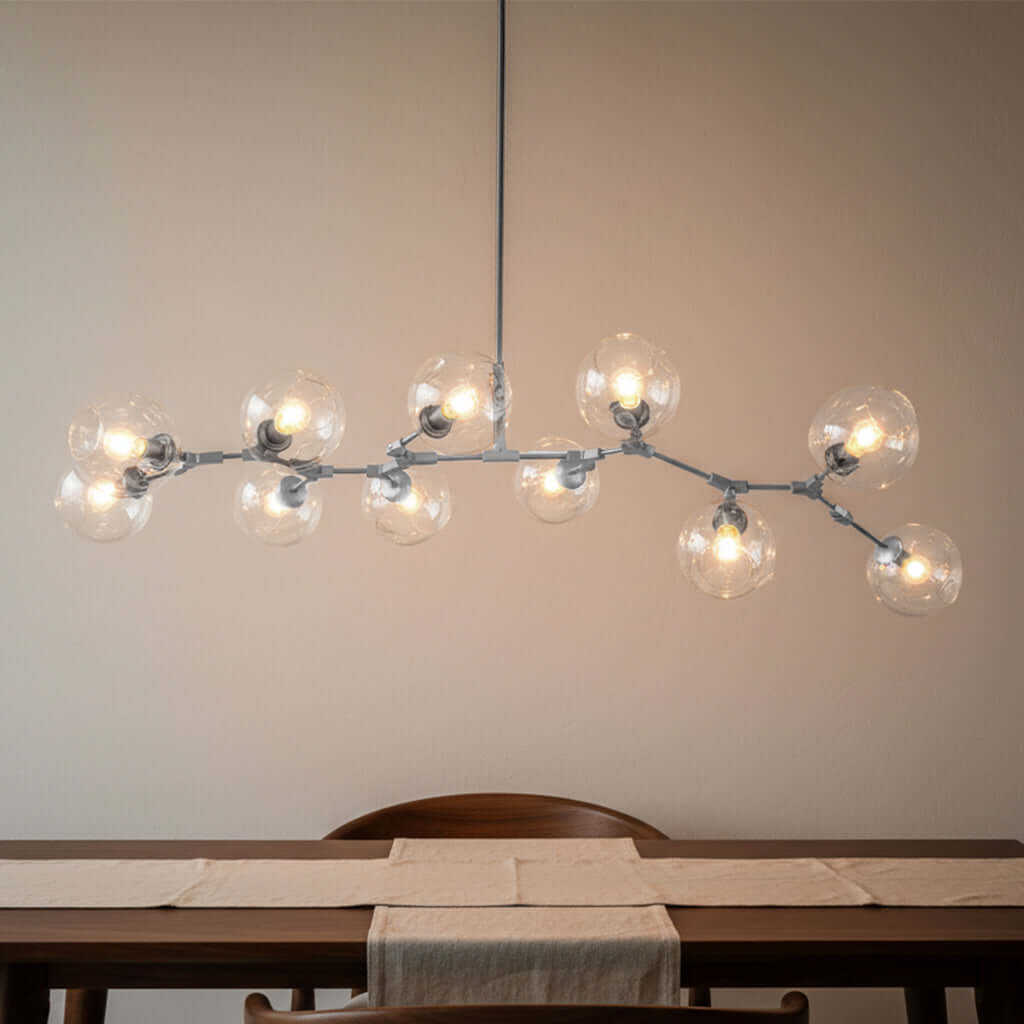 Modern chandelier with multiple light bulbs hanging above a dining table.