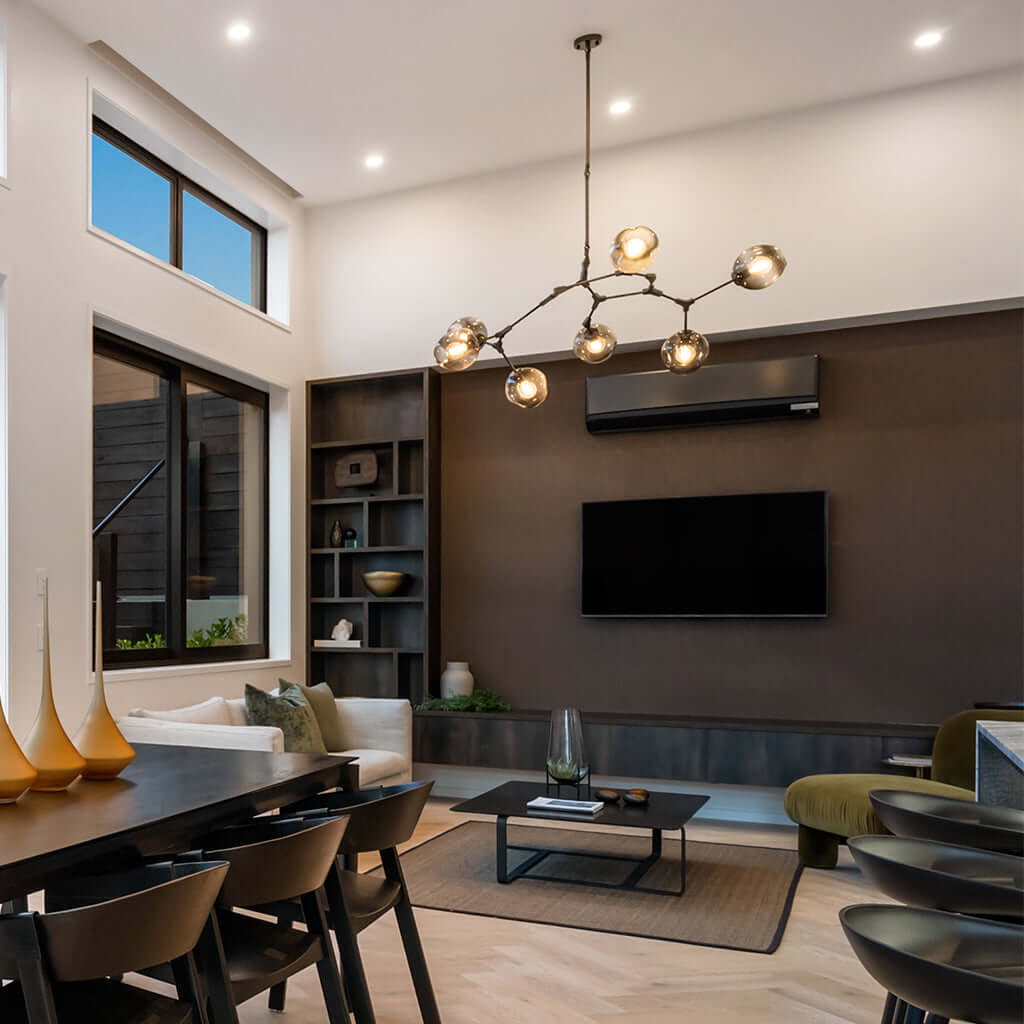 Modern living room with a chandelier, TV, and dining table.