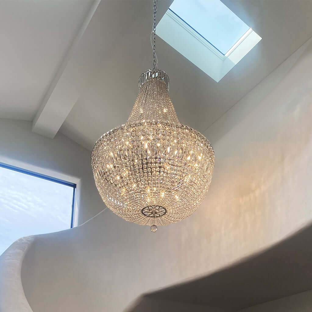 Chandelier hanging from the ceiling in a room with skylights.