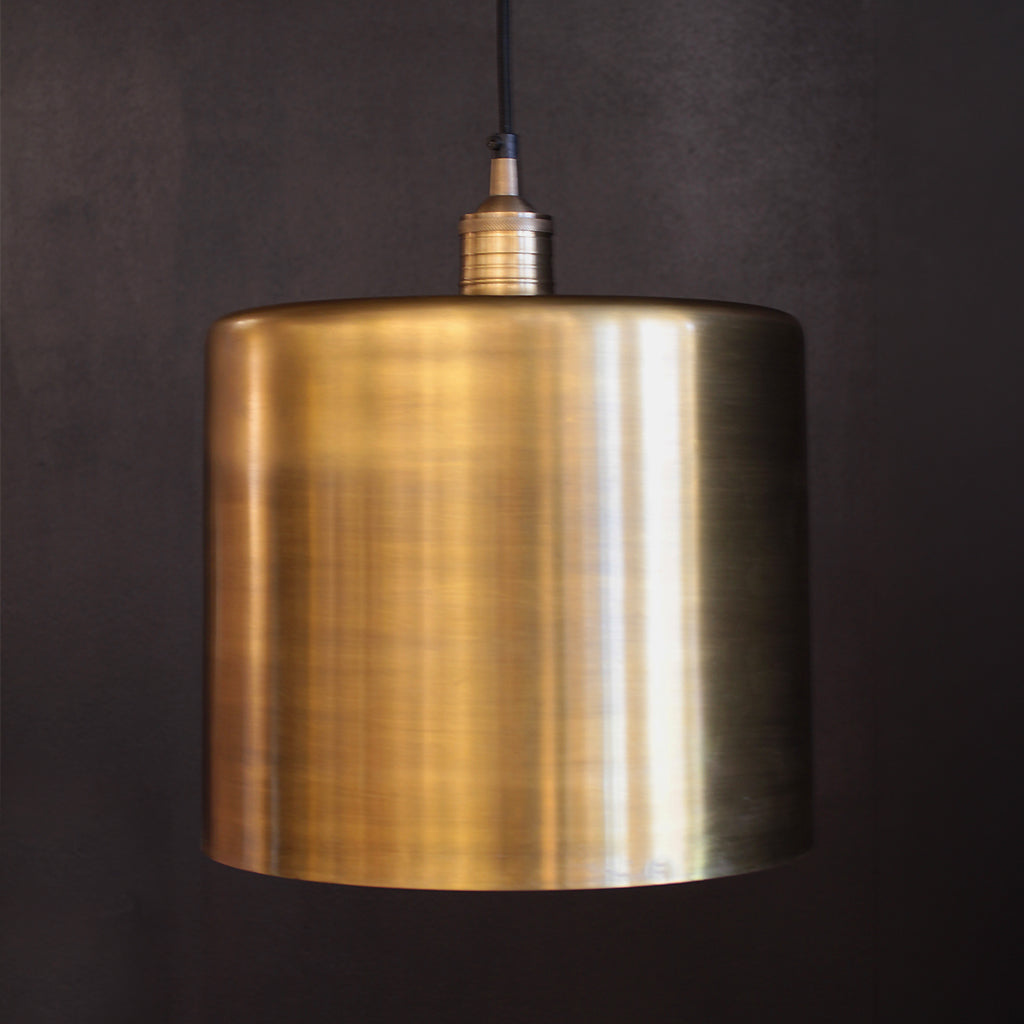 Brass pendant light against a dark background