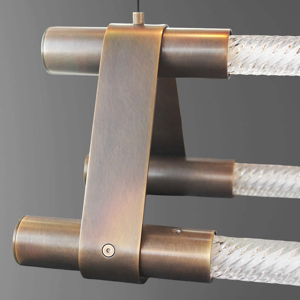 Close-up of a bronze or brass pendant light on a gray background