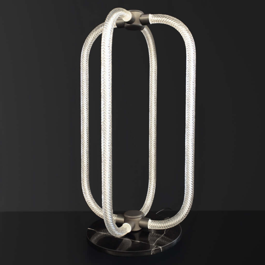 Modern table lamp with braided glass design on a black background