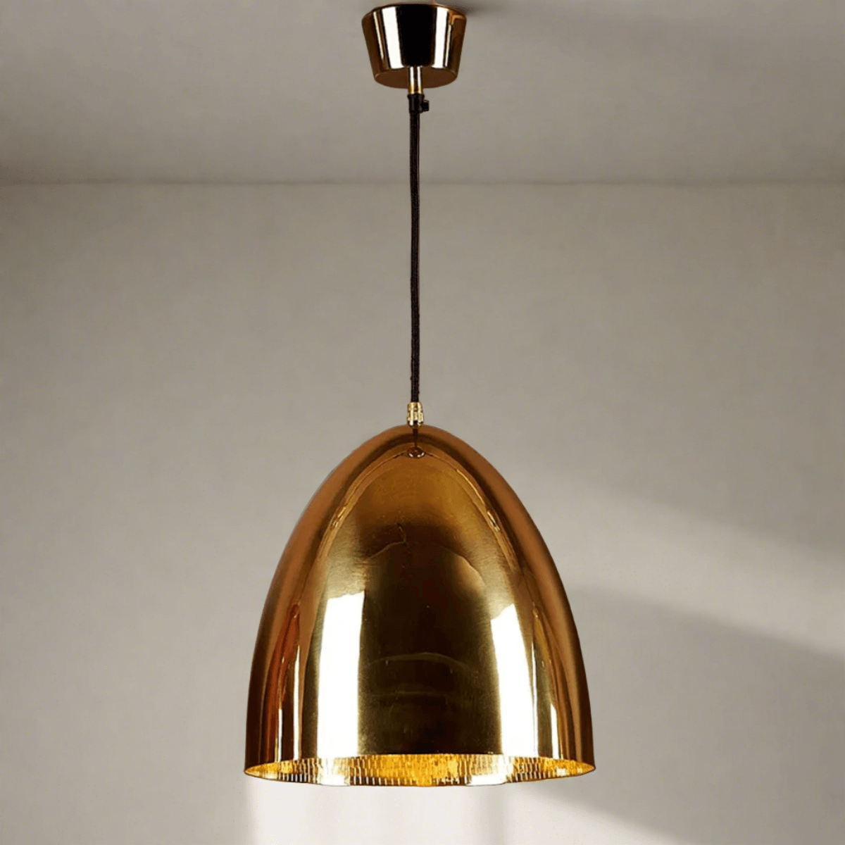 Dining room with wooden table and chairs, abstract art on the wall, and brass pendant light.