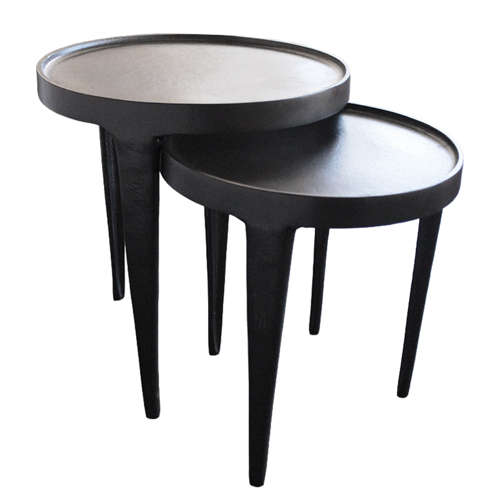 Two black nesting tables with thin legs on a white background