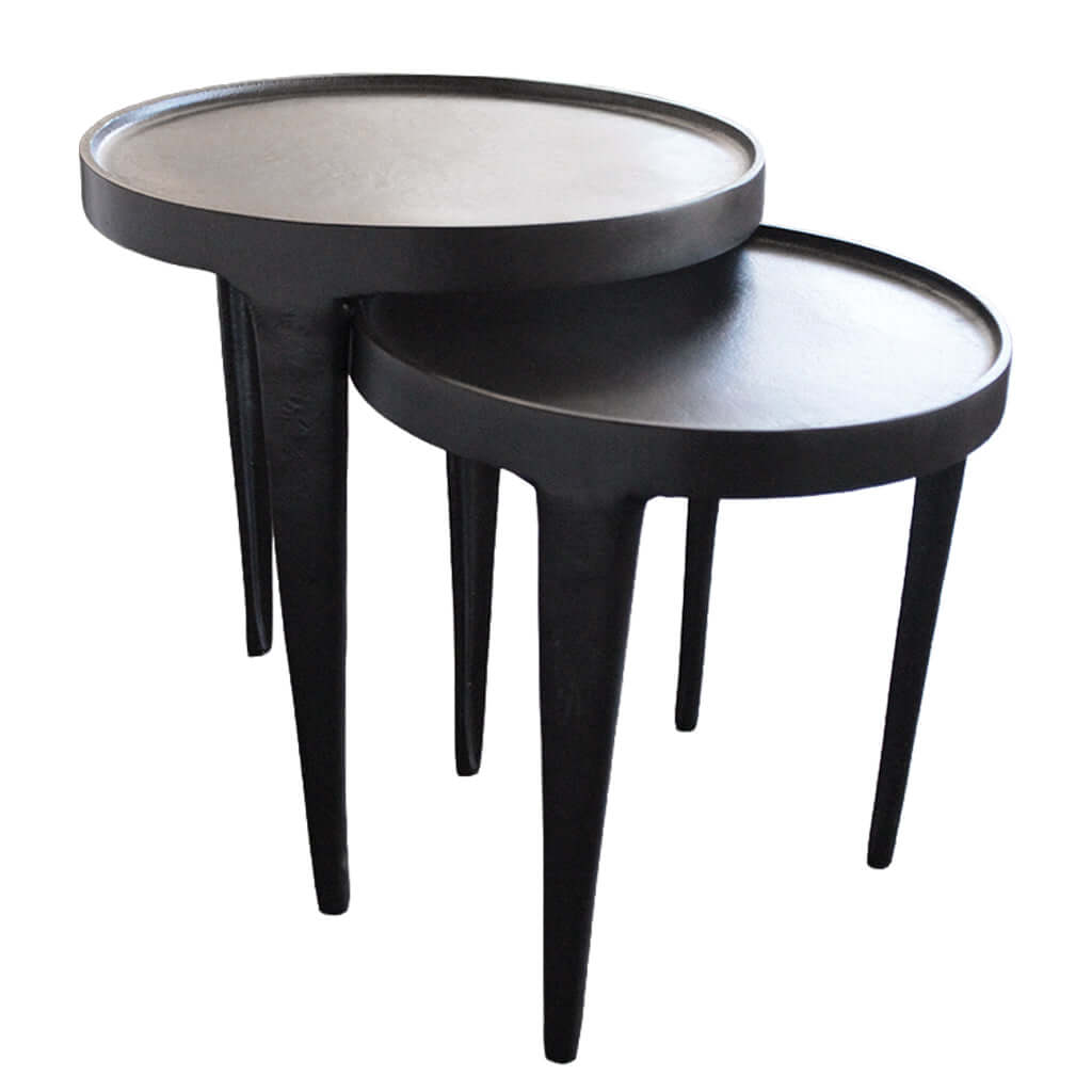Two black nesting tables with thin legs on a white background
