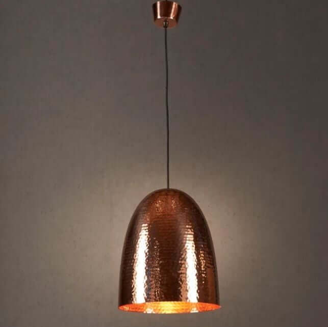 A tall domed pendant light with a hammered metal texture, constructed from a brass base, with a copper finish.