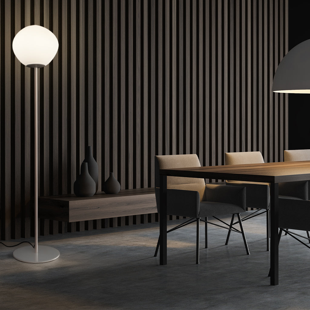 A modern floor lamp featuring a large, organic-shaped frosted white glass globe shade on a slim white metal stand.