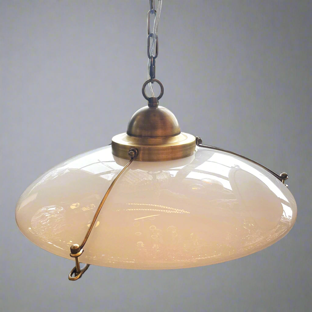 Vintage-style pendant light with frosted glass shade and brass fixture.