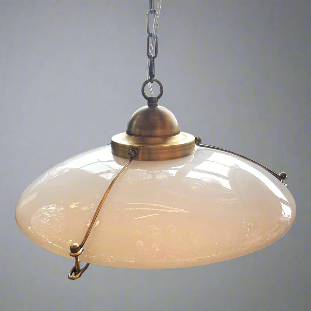 Vintage-style pendant light with frosted glass shade and brass fixture.