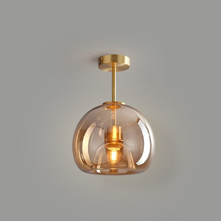 A Deon ceiling light with a tinted amber glass shade and brass fittings