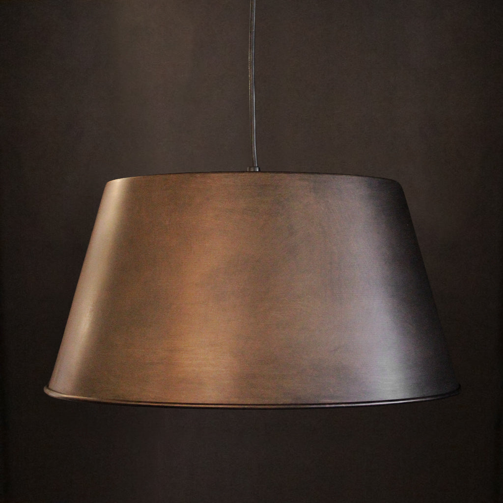 Tapering bronze pendant light shade against a dark background