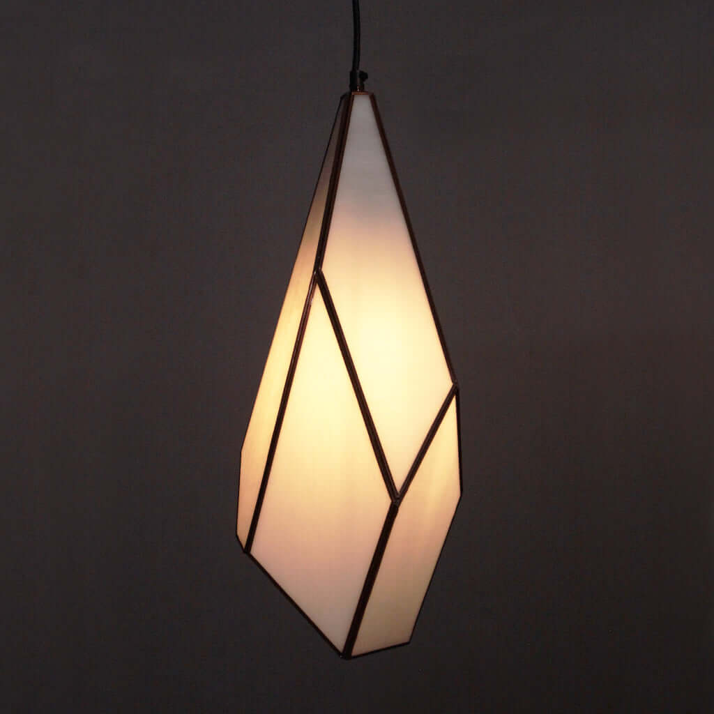 Geometric pendant light with a warm glow on a dark background