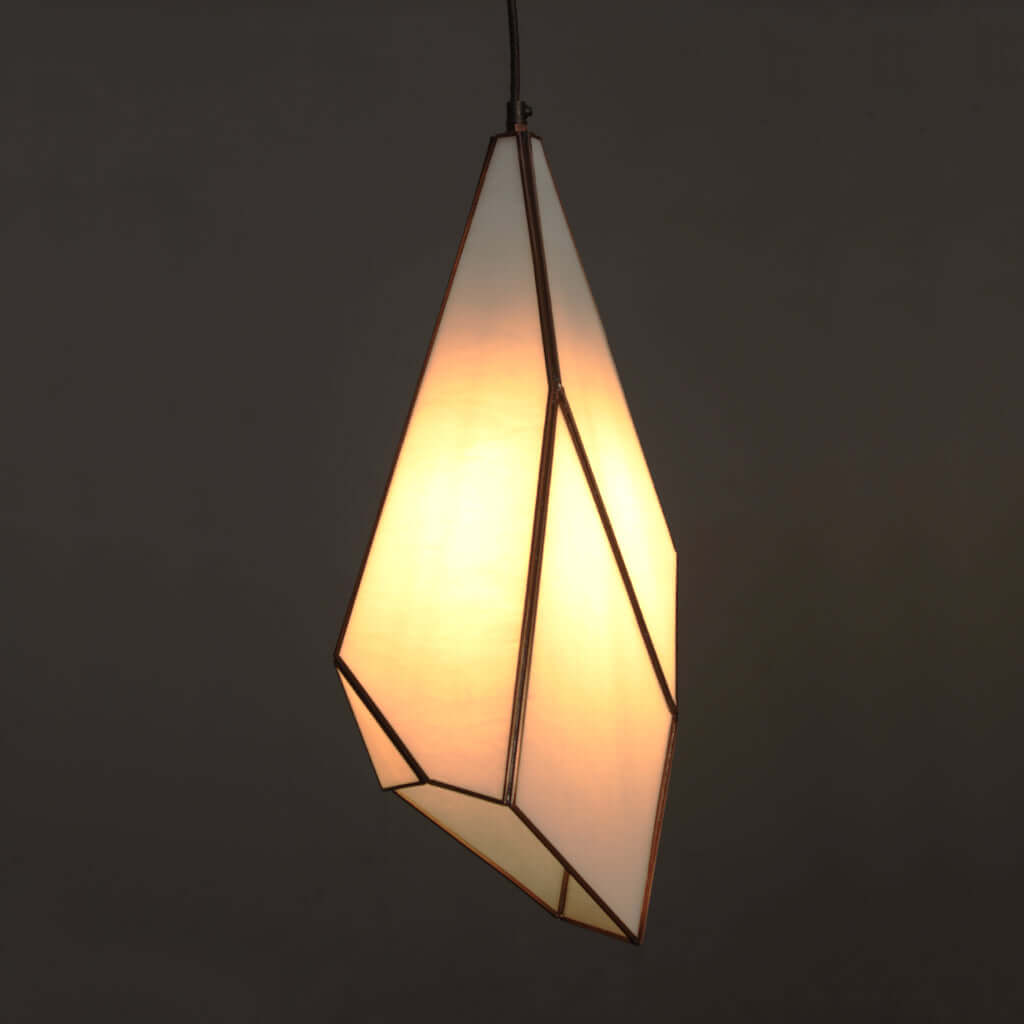 Geometric pendant light with warm glow on a dark background