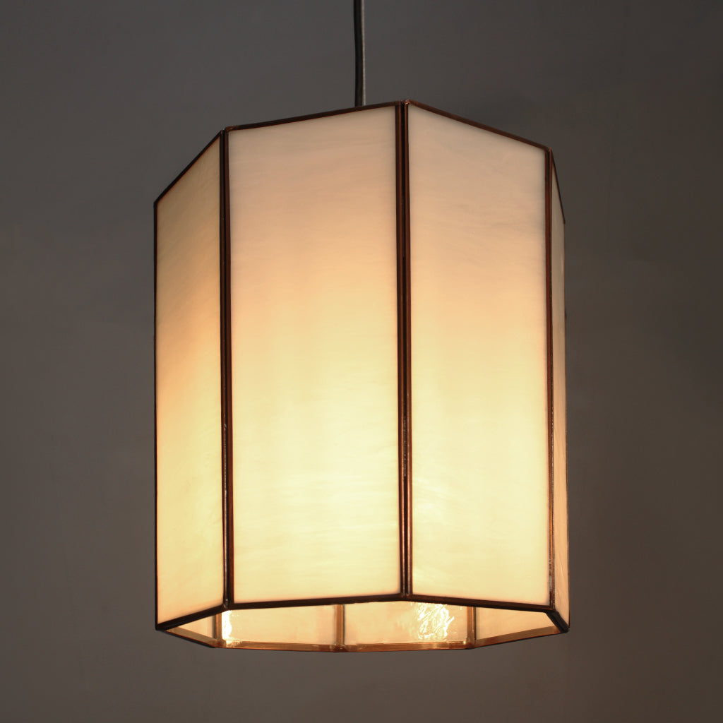 Dining room with wooden table and chairs, illuminated by pendant lights.