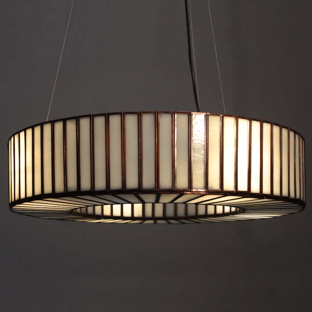 Modern pendant light with a cylindrical design on a dark background