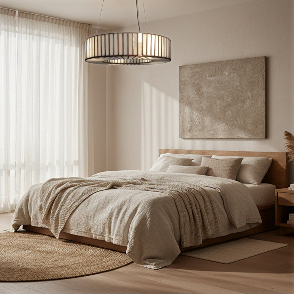 Modern bedroom with a bed, lamp, and artwork on a neutral color scheme.