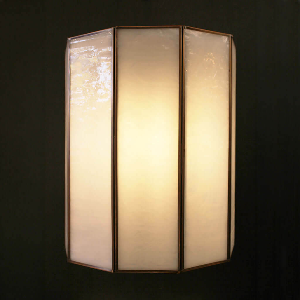 Decorative wall light with a glass panel on a black background