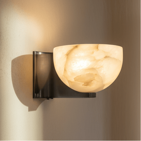 Wall-mounted light fixture with marble-like stone shade on a neutral wall.