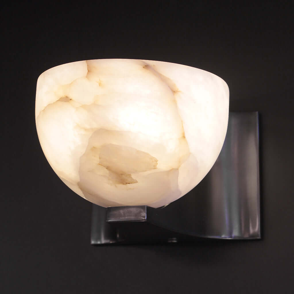 Wall-mounted light fixture with marble-like stone shade on a neutral wall.