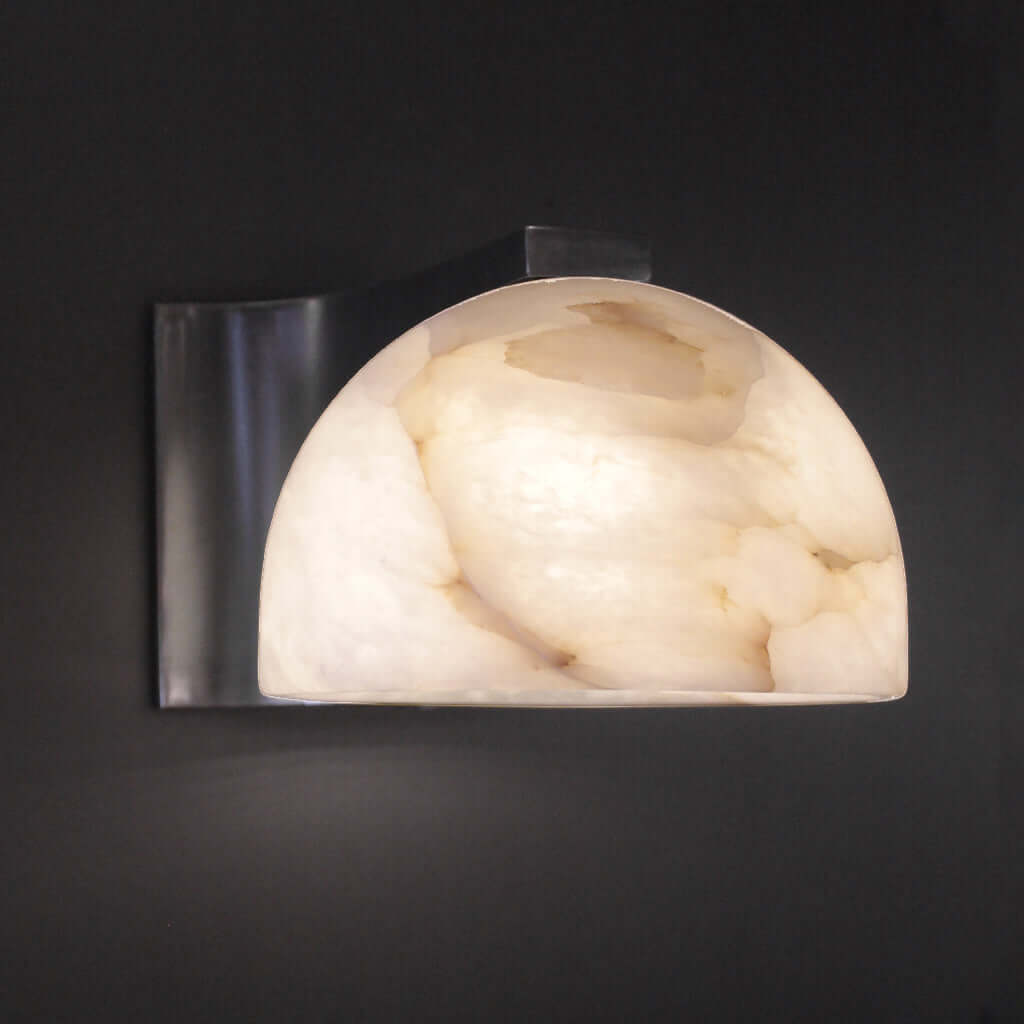 Wall-mounted light fixture with marble-like shade on a dark background