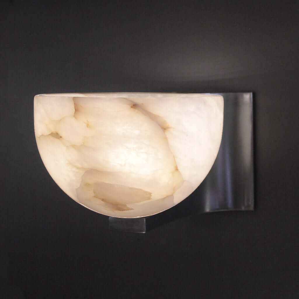 Wall-mounted light fixture with marble-like shade on a dark background