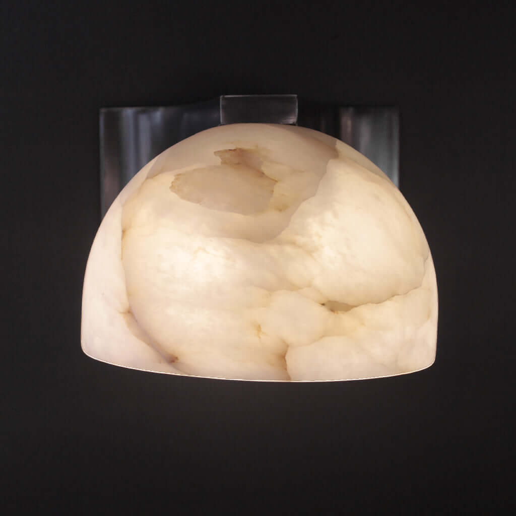 Decorative wall sconce with a marble-like finish on a black background