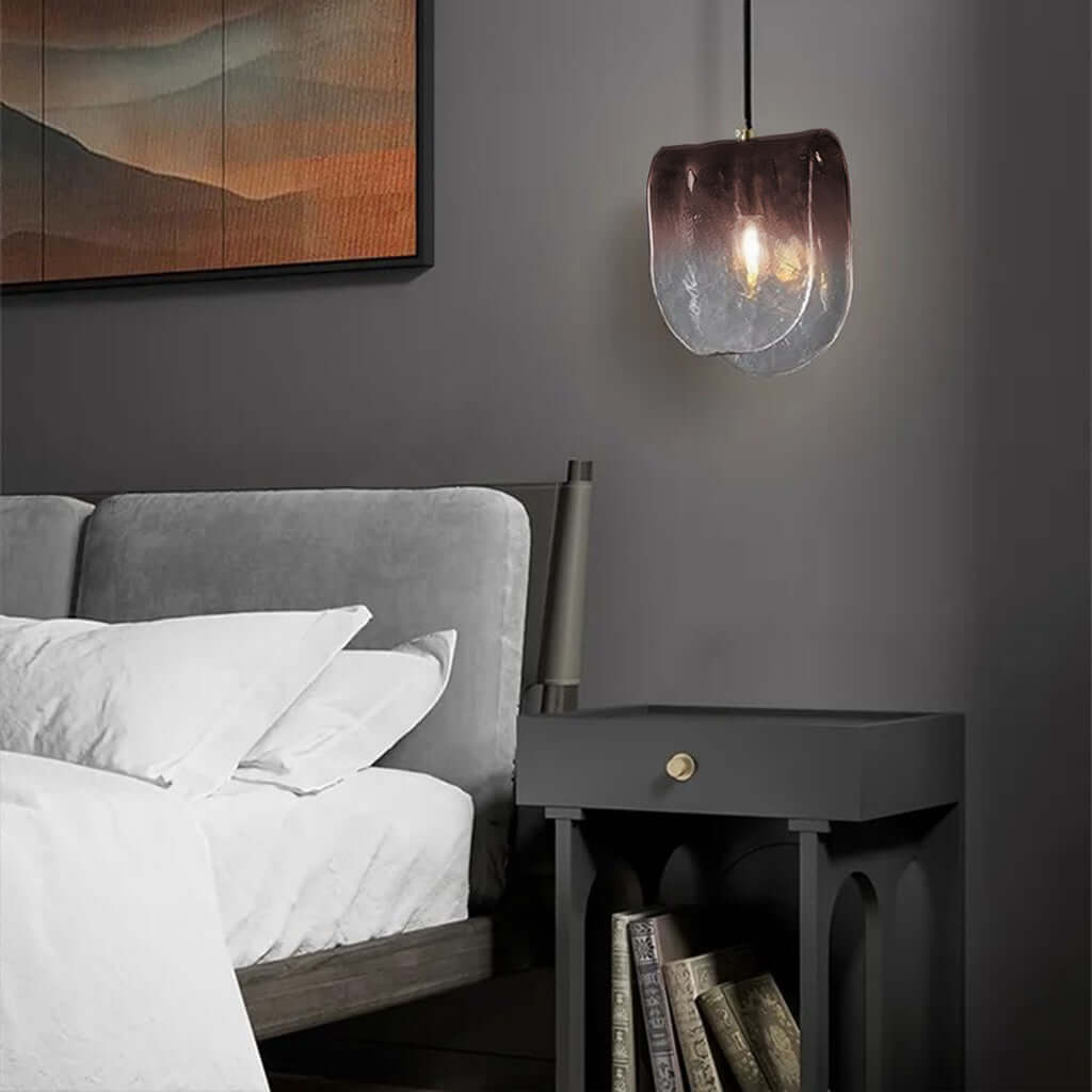 Modern pendant light with a glass shade on a dark background