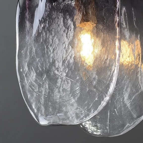 Close-up of a textured glass light fixture with a warm glow on a dark background