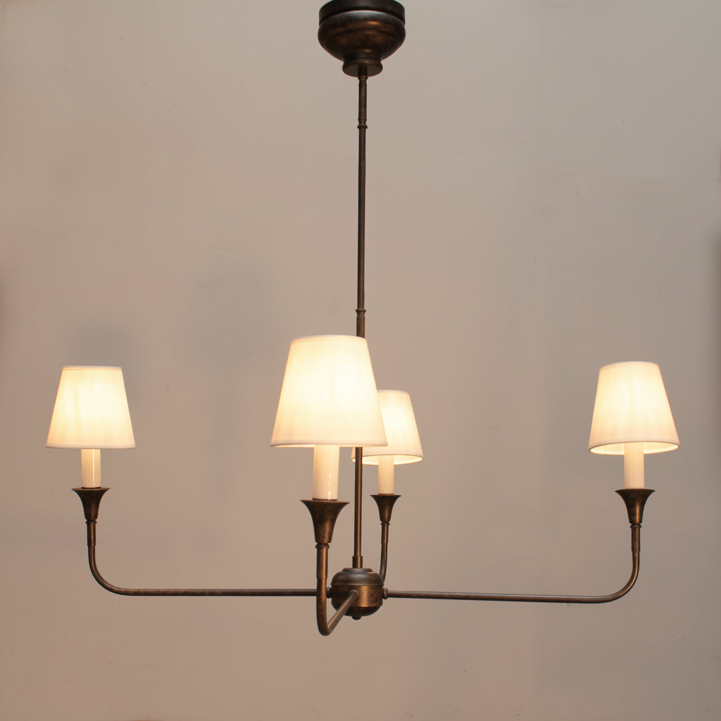 Chandelier with four lit lampshades against a gray background