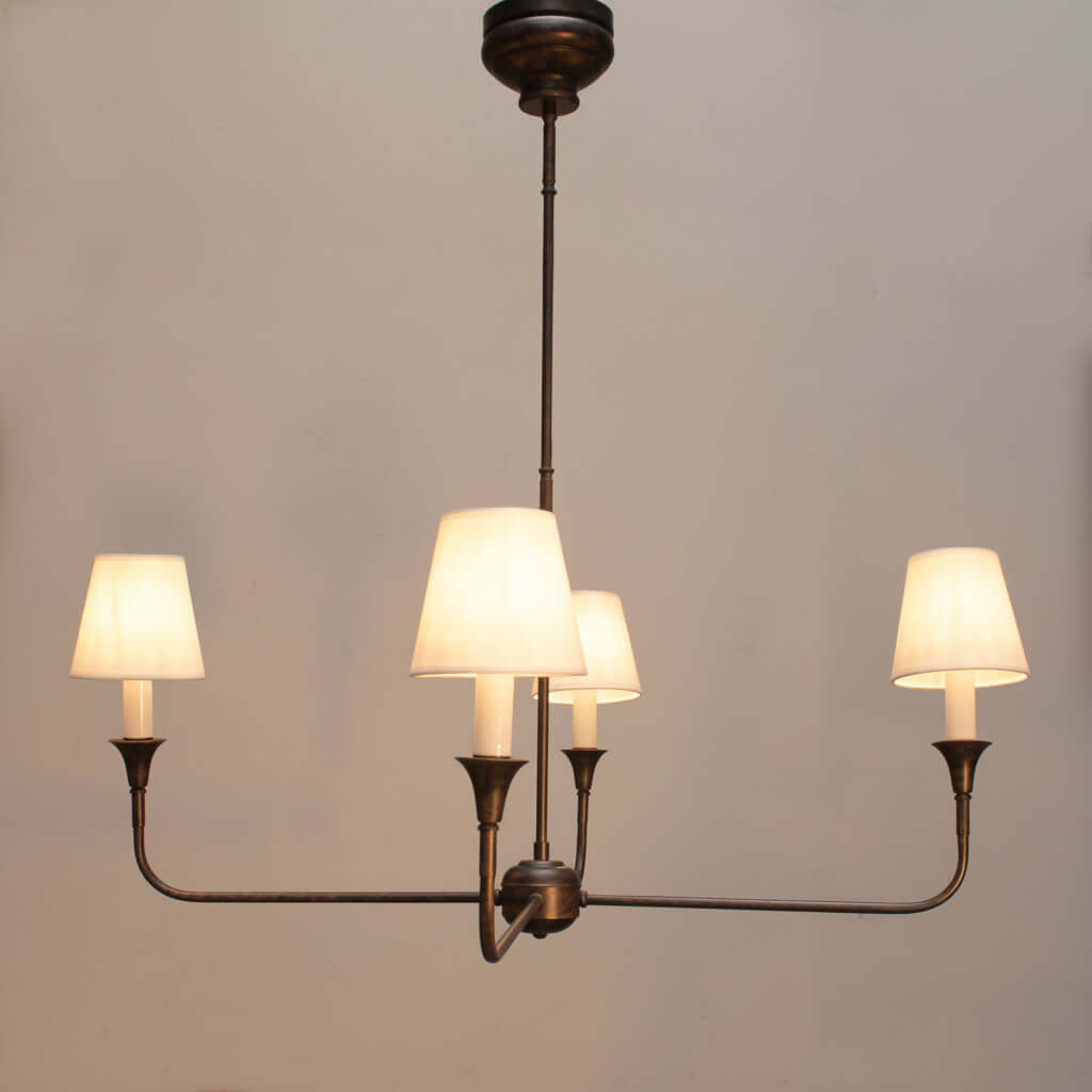 Chandelier with four lit lampshades on a dark gray background