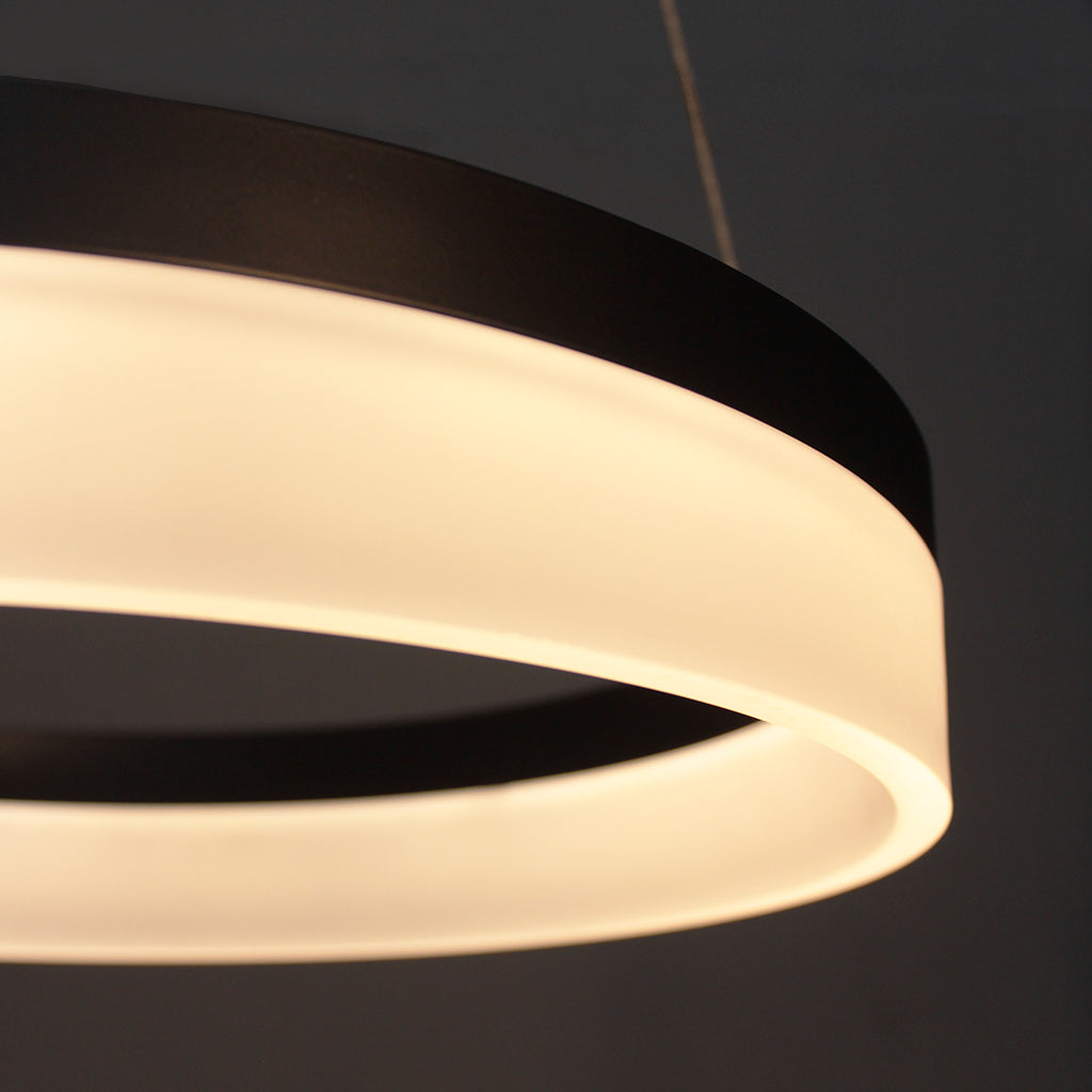 Modern pendant light with two concentric circular designs on a dark background