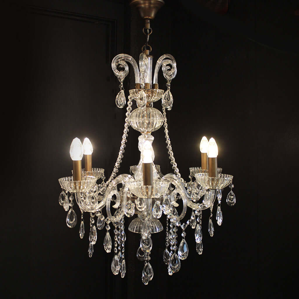 Crystal chandelier with six light bulbs on a black background