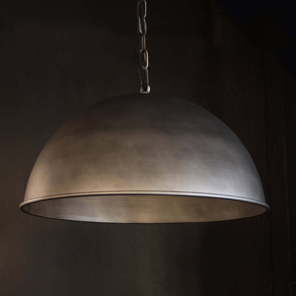 Brushed nickel industrial domed pendant light with dark background
