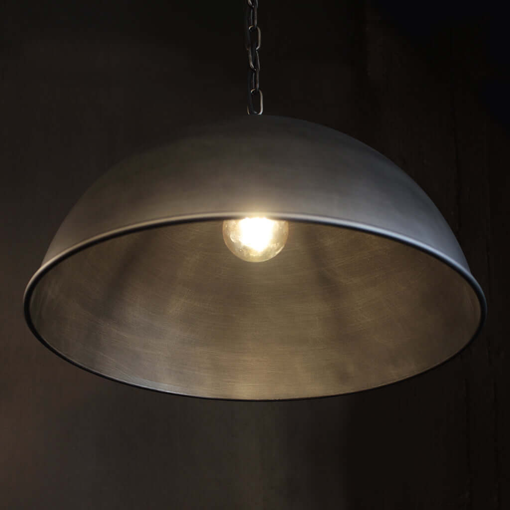 Brushed nickel industrial domed pendant light with dark background