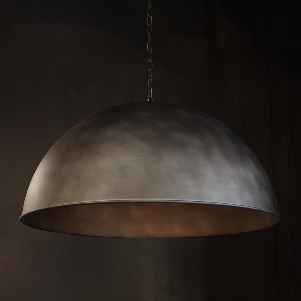 A large dome-shaped pendant light with a textured, metallic Silver finish, hanging from a chain against a dark background.