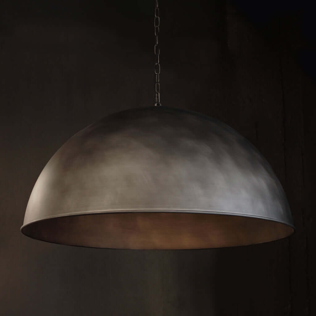 A large dome-shaped pendant light with a textured, metallic Silver finish, hanging from a chain against a dark background.