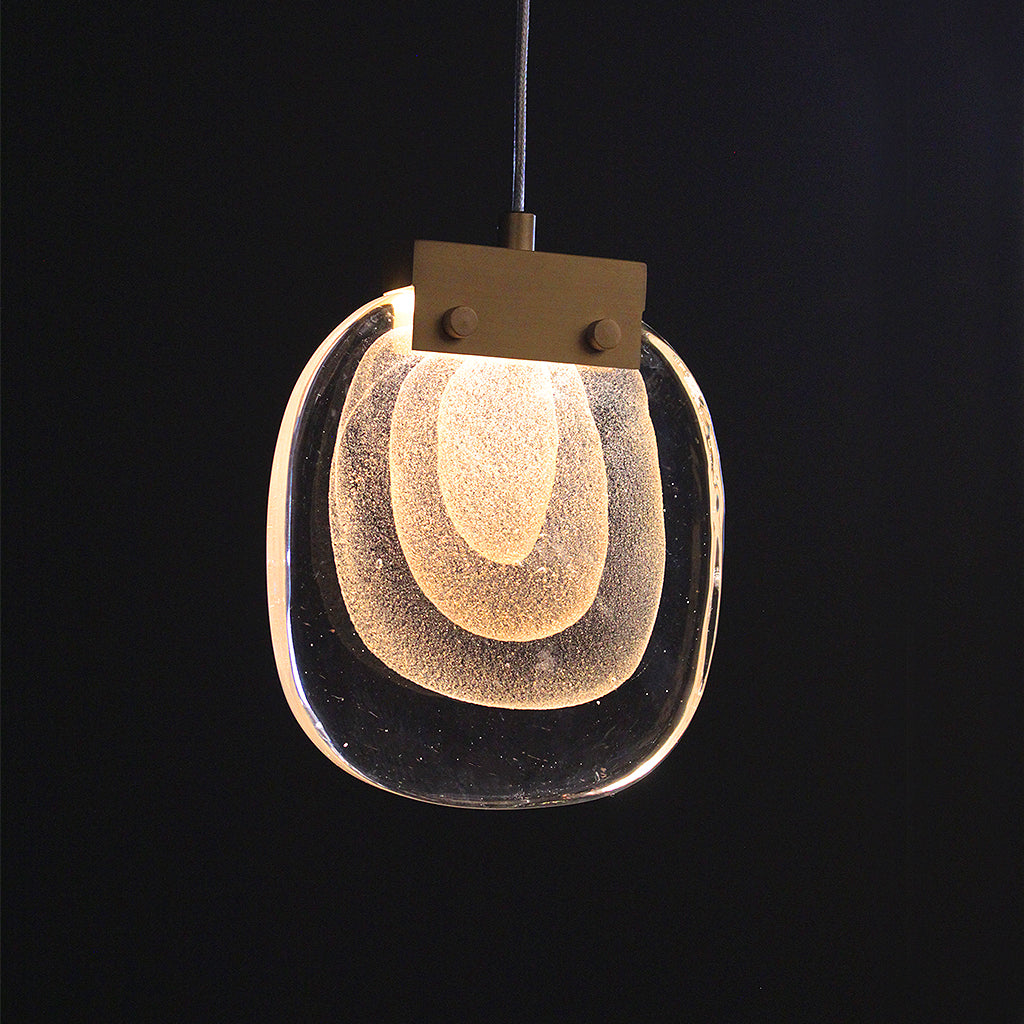 Pendant light with a textured glass shade on a black background