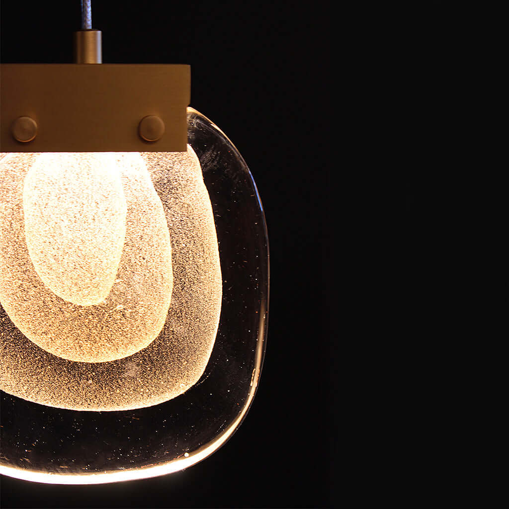 Modern pendant light with a glass shade on a black background