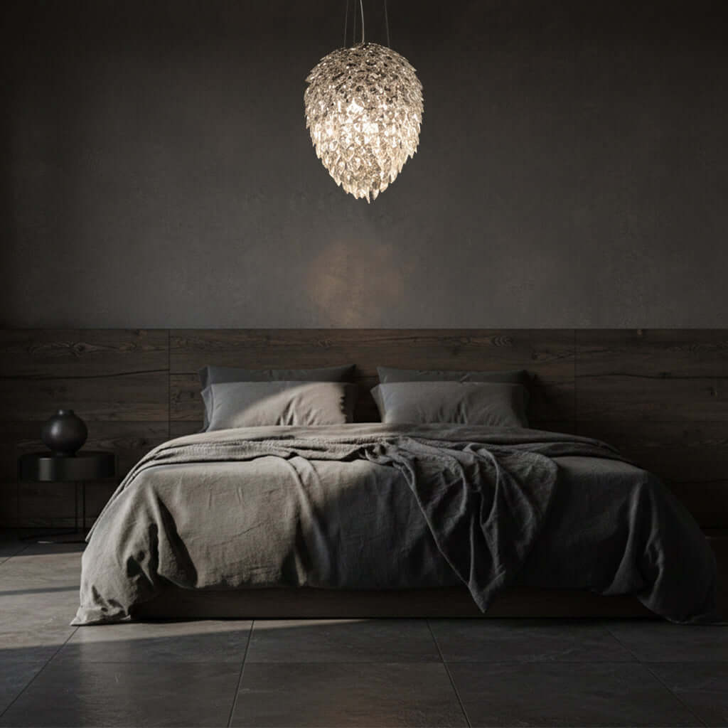 Dark bedroom with a bed and a large crystal pendant light fixture.